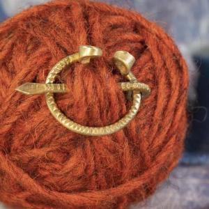 Pevná mosazná fibula na sepnutí pláště s rýhovaným vzorem