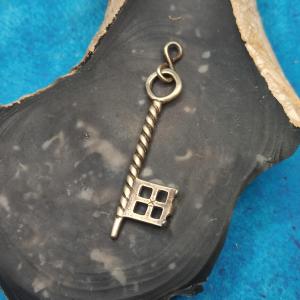 Malý klíč na řetízek zavěšený na brožích VIKING